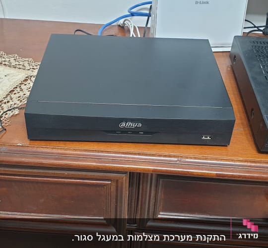 מכשיר הקלטה של מצלמות אבטחה על שולחן עץ
